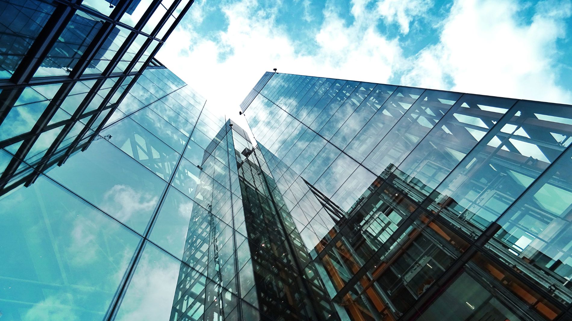 Blick auf moderne Glasfassaden eines Bürogebäudes unter blauem Himmel.
