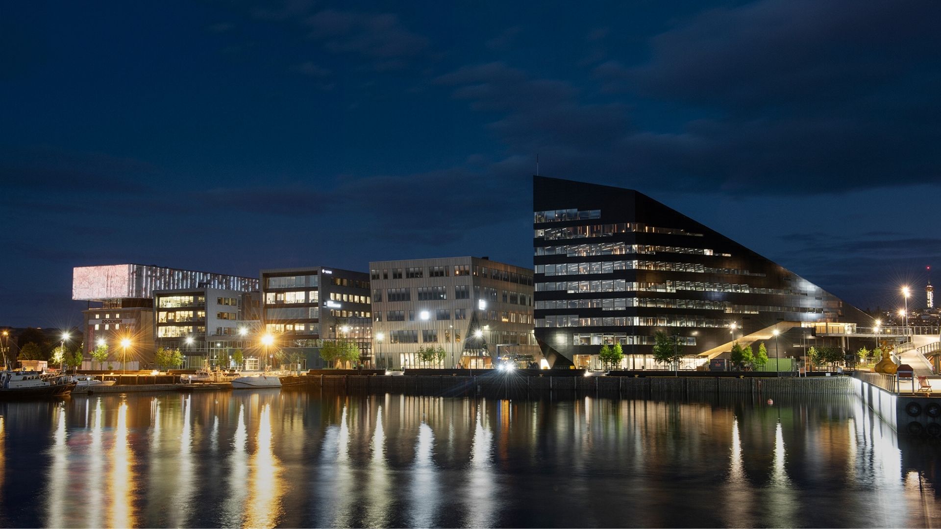 Energiepositive Bürogebäude am Wasser bei Nacht