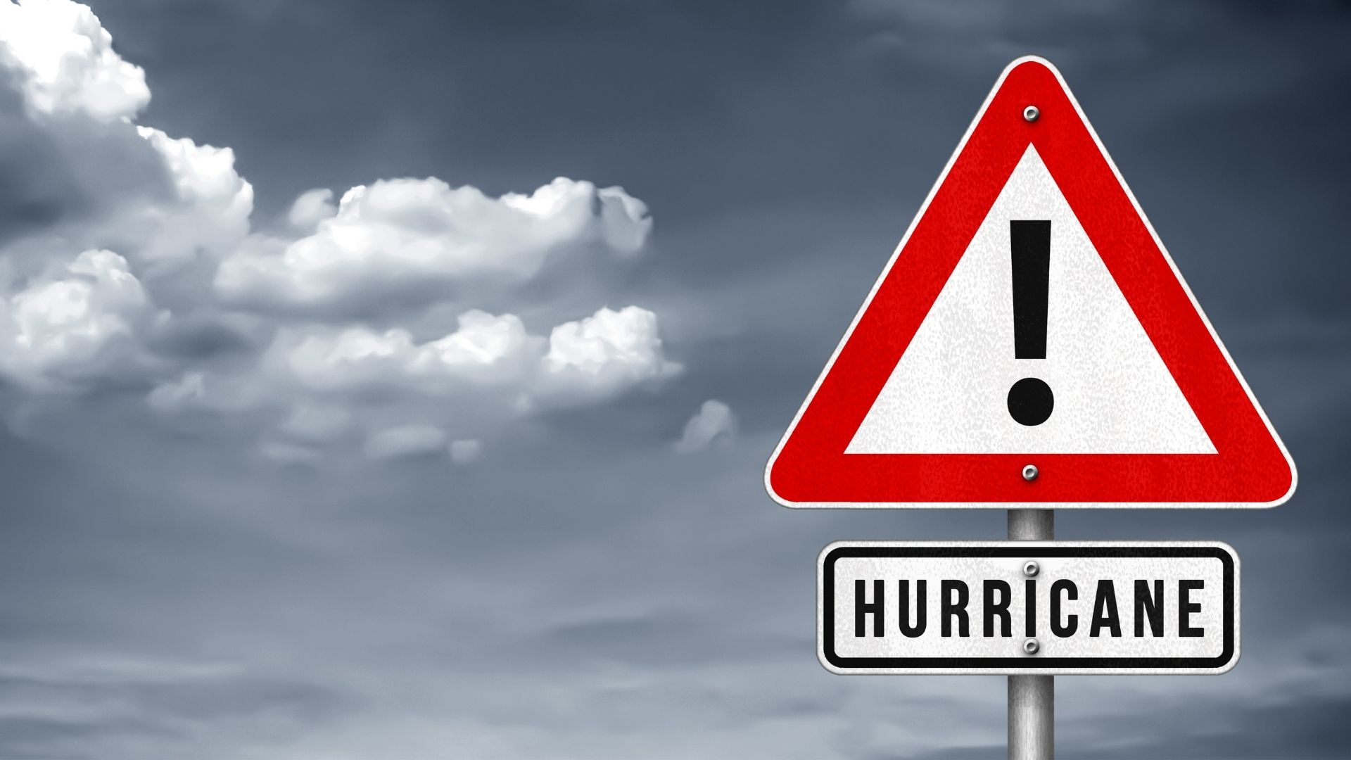 Hurricane warning sign under dark cloudy sky