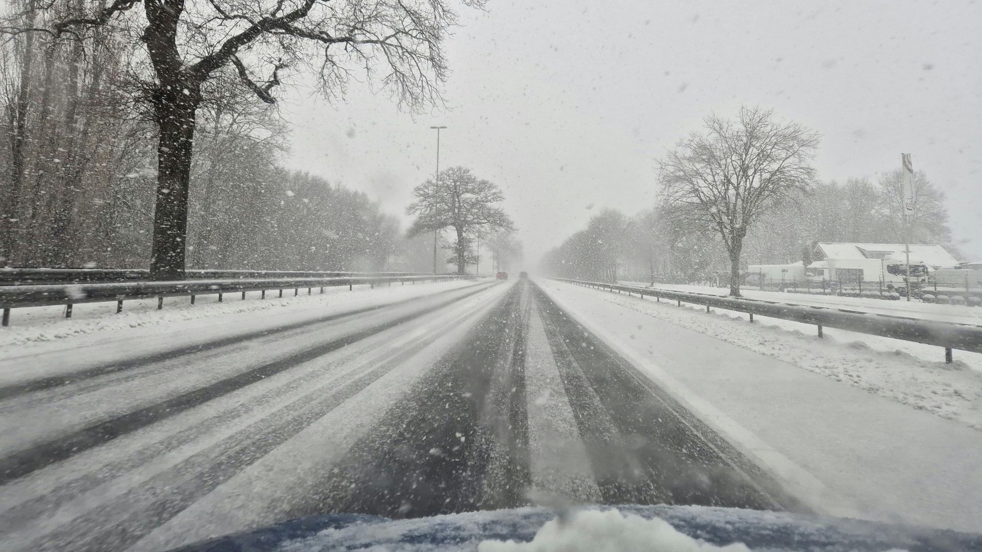 Snow-covered road during heavy snowfall and low visibility