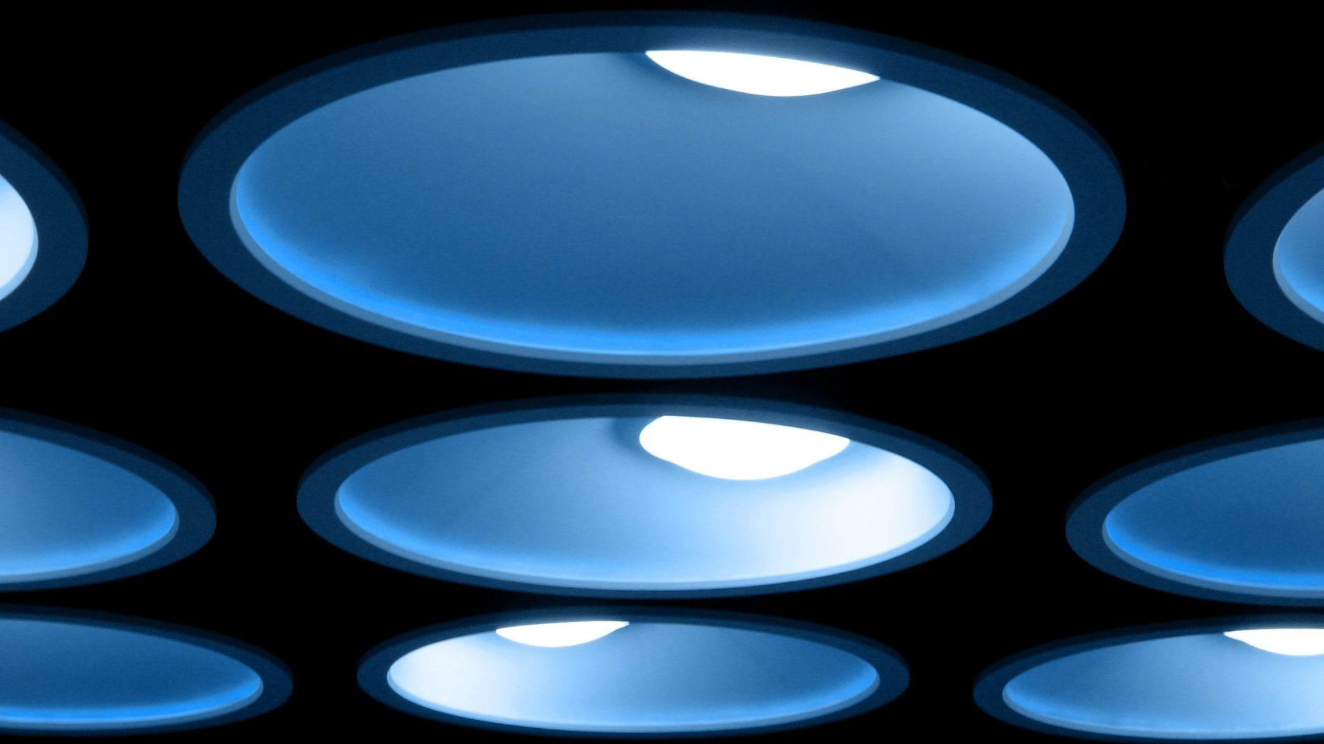 Abstrakte blaue Lichtformen auf schwarzem Hintergrund