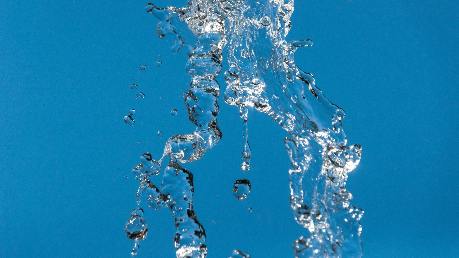 Water droplets and splashes on blue background