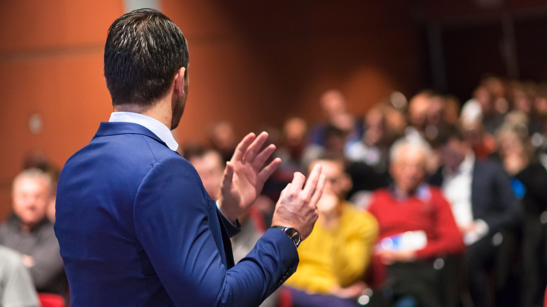 Man gives a lecture in front of an audience