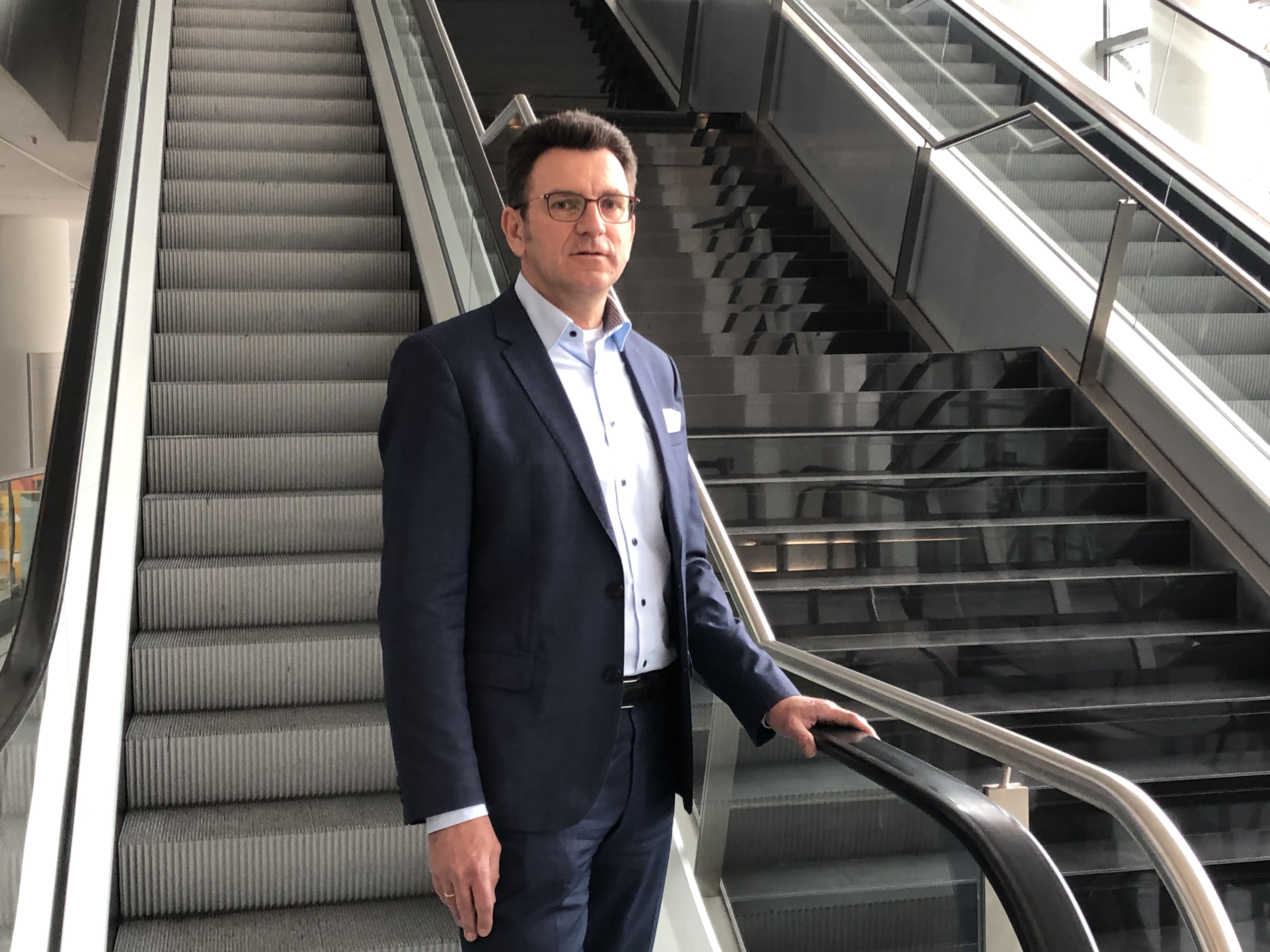 Hands on the escalator handrail: Olaf Kühl's, Head of Facility Management at Messe Frankfurt Venue, rests on germ-free handrail surface in the CMF.